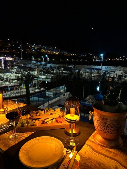 Akşam, şarap ve peynir tabağı, marina manzarası